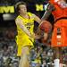 Michigan freshman Spike Albrecht passes the ball under the net and around Syracuse sophomore Rakeem Christmas in the second half of the Final Four in Atlanta on Saturday, April 6, 2013. Melanie Maxwell I AnnArbor.com